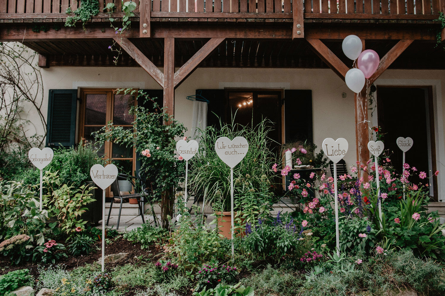 handwritten signs with good wishes in garden outside bride's house at boho wedding