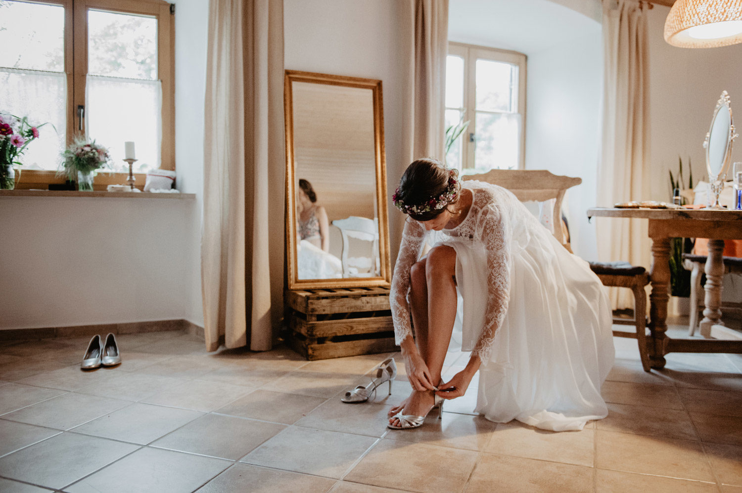 boho bride wearing elfenkleid dress putting on rosegold wedding shoes 