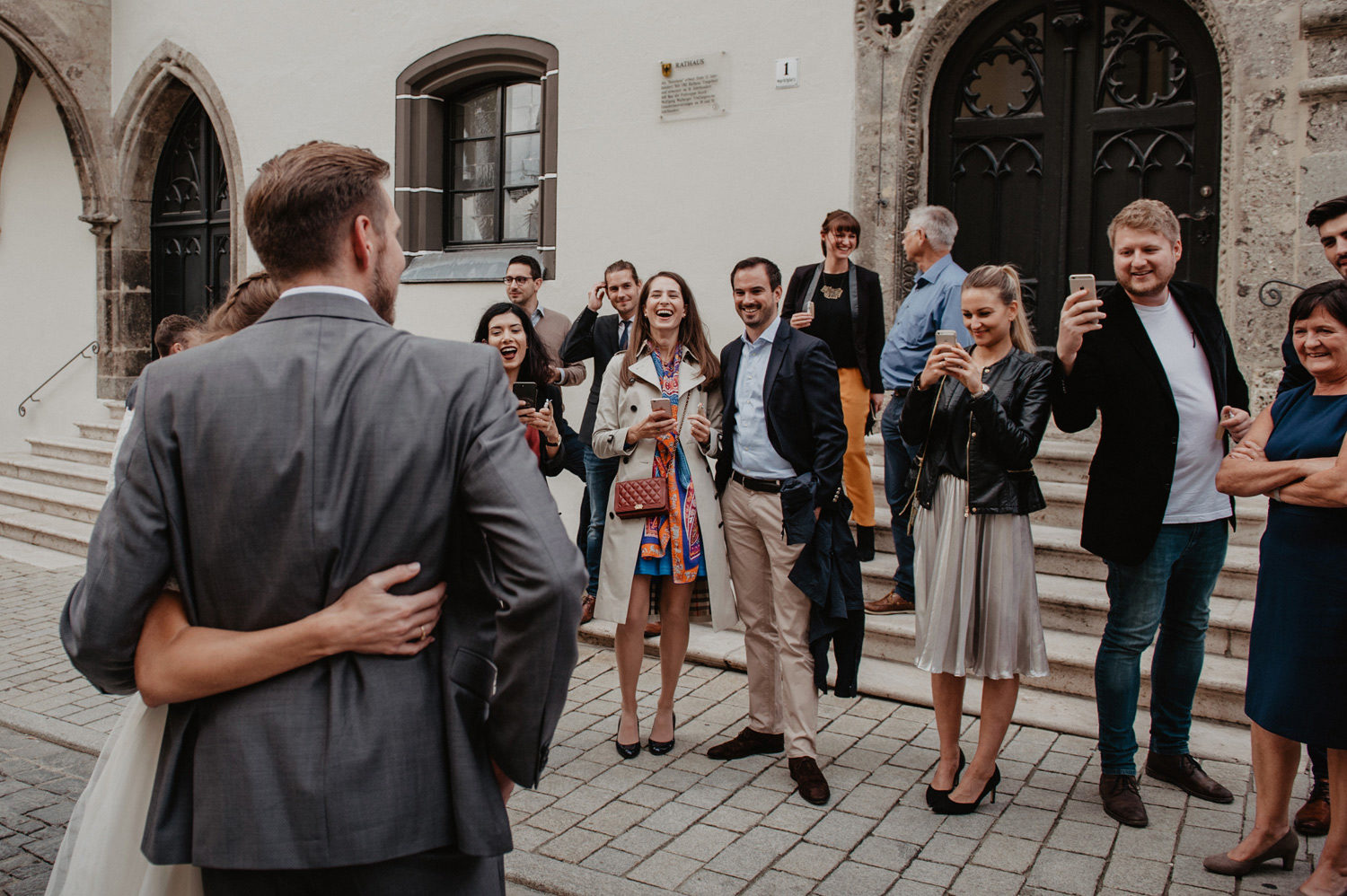 boho couple in front of laughing friends taking pictures 