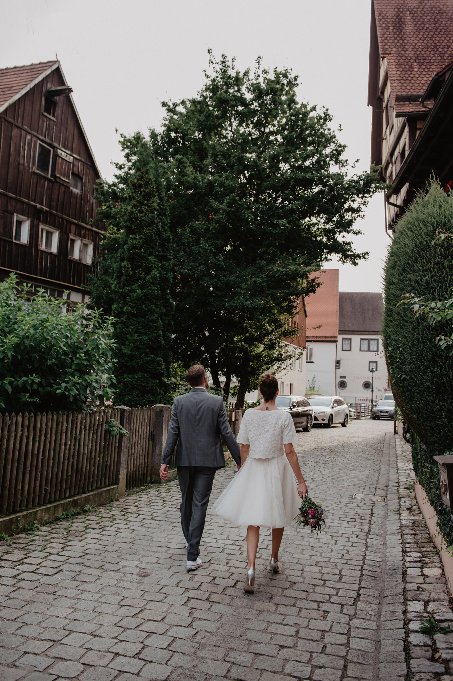 boho wedding couple walking on cobbled street with cute wooden traditional houses noerdlingen germany
