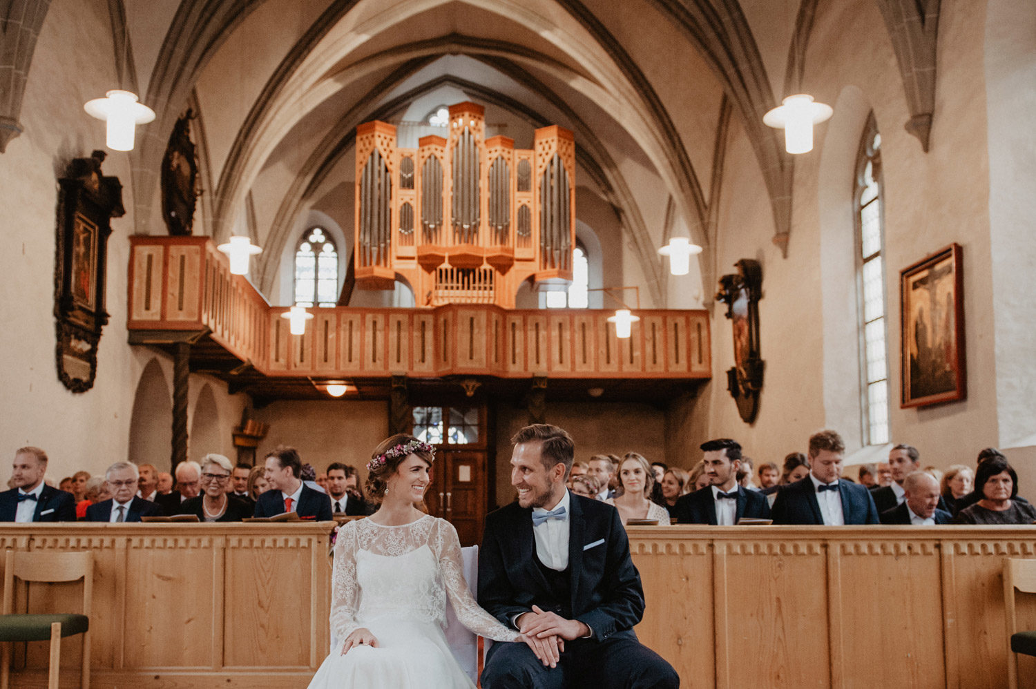 bride and groom looking at each other in blonde wood panelled scandi style church