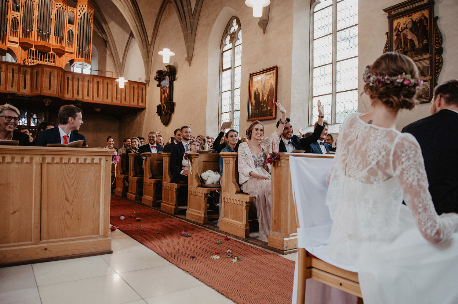 wedding guests raising hands in participation in scnadi style midcentury modern church