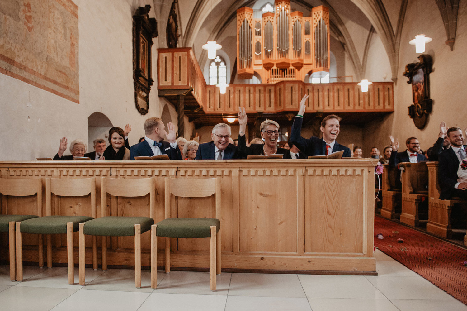 wedding guests raising hands in participation in scnadi style midcentury modern church