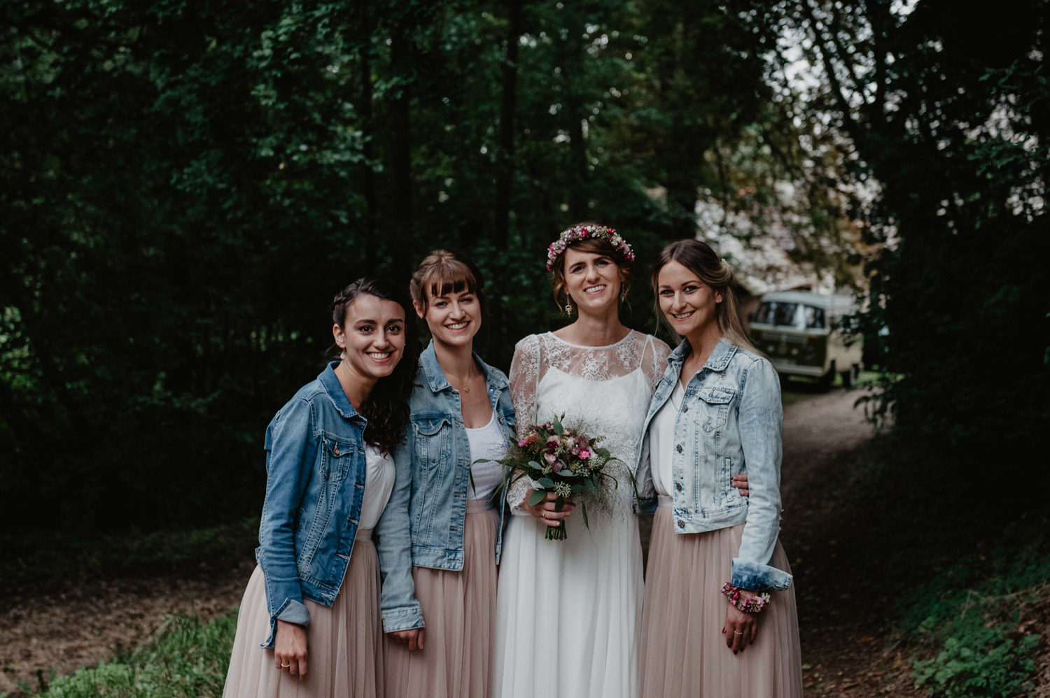 boho bride with flowercrown and bridesmaids in denim jackets pastel tulle skirts with balloons at tipi wedding 