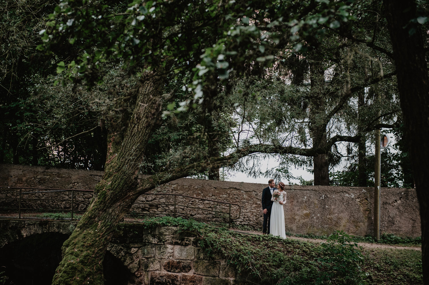 boho bride and groom posing in enchanted dark moody forest