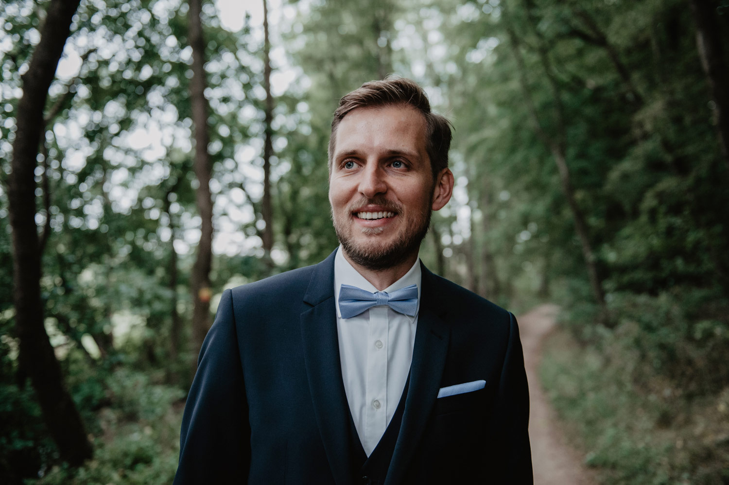 groom in dark blue suit and tie 