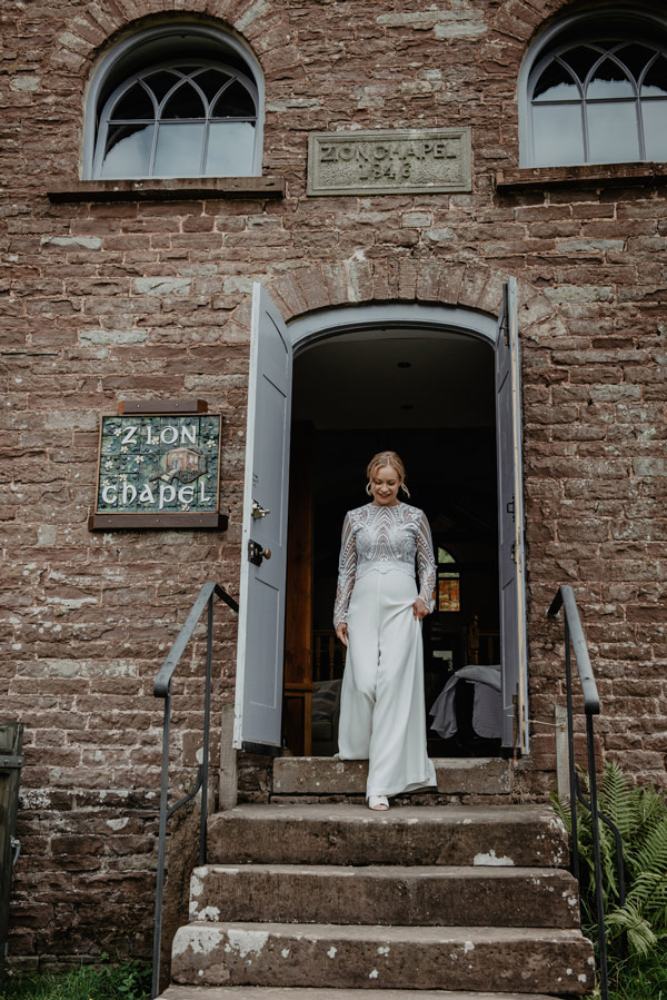 bride leaving farmhouse for ceremony at shropshire barn wedding